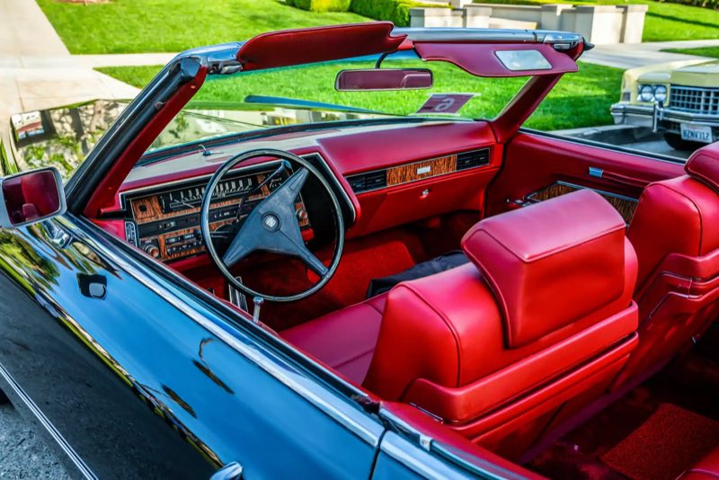 Red leather seats and dashboard of the black 1970 Cadillac DeVille convertible