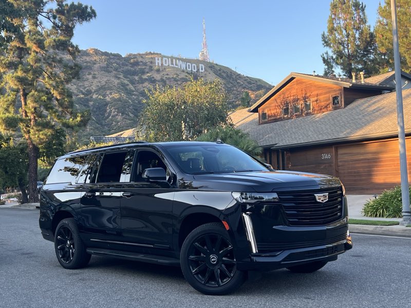 Black Cadillac Escalade in front of the Hollywood Sign