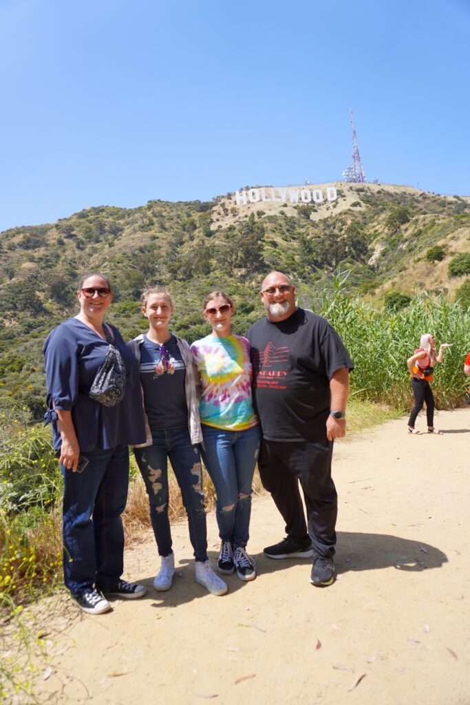 A group of four on a hiking trail below the Hollywood Sign