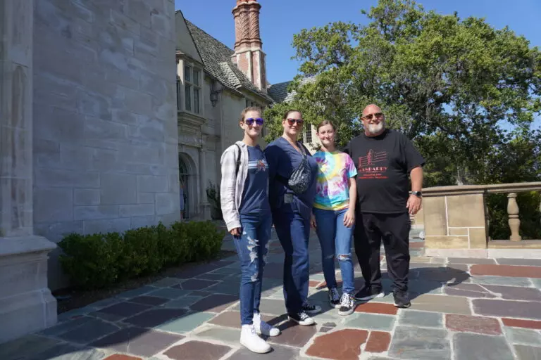 A family of four on the stone terrace of Greystone Mansion