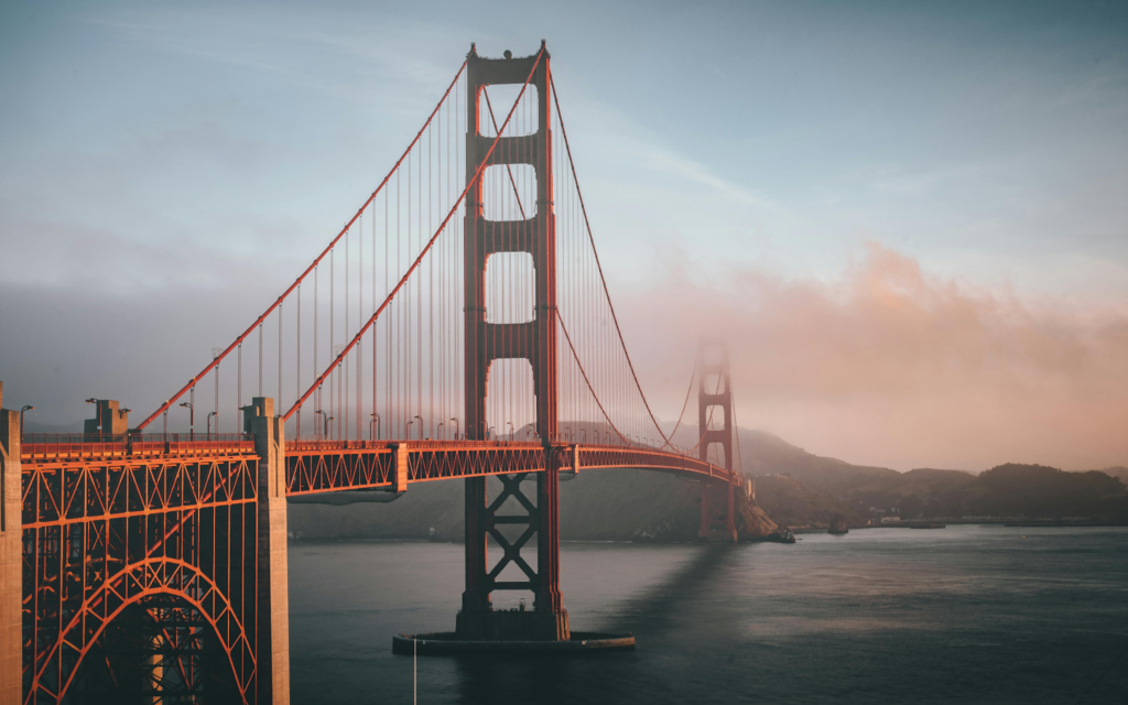 Golden Gate Bridge tower rising above the bay in evening fog