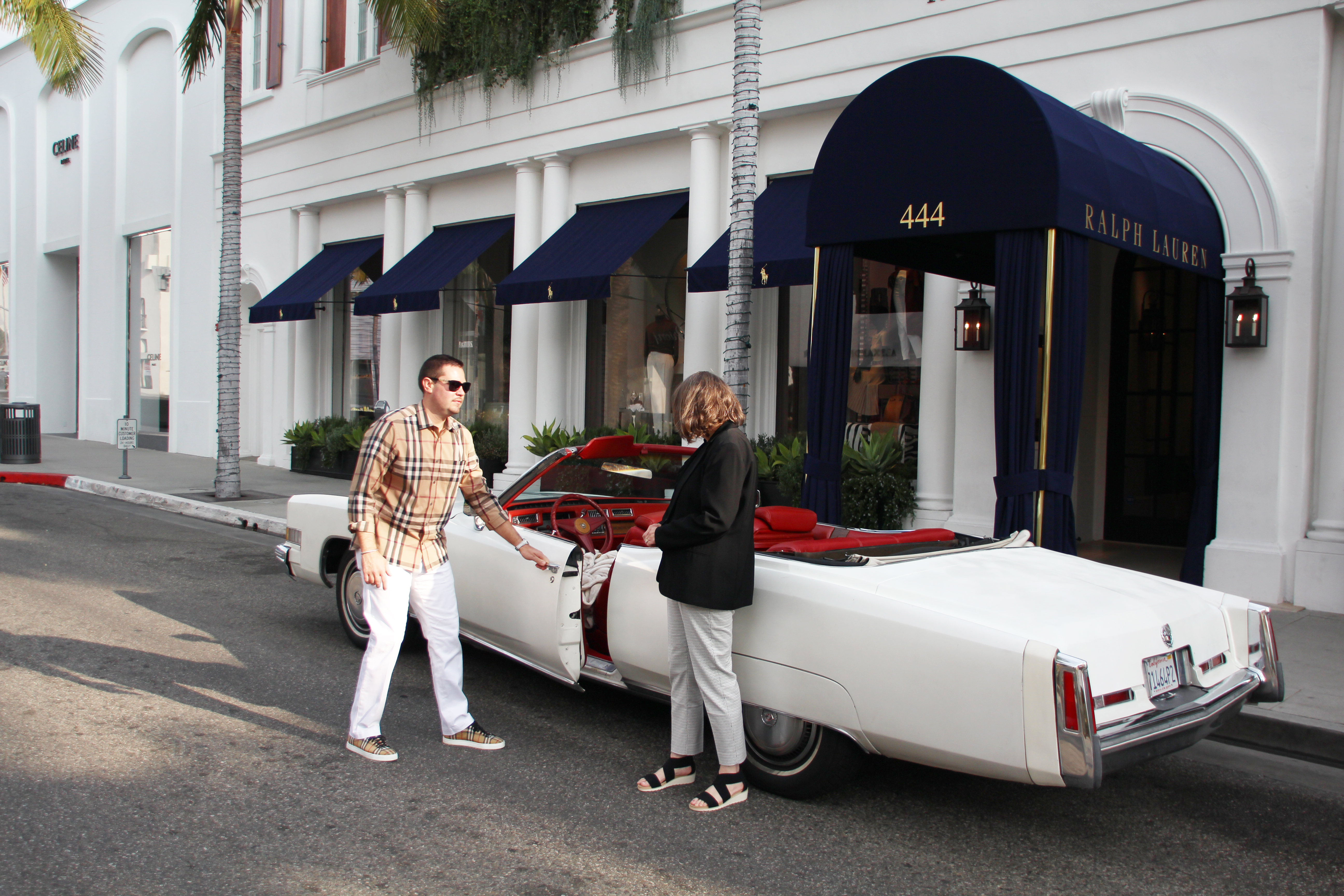 Guests with a white vintage Cadillac convertible on a Los Angeles tour